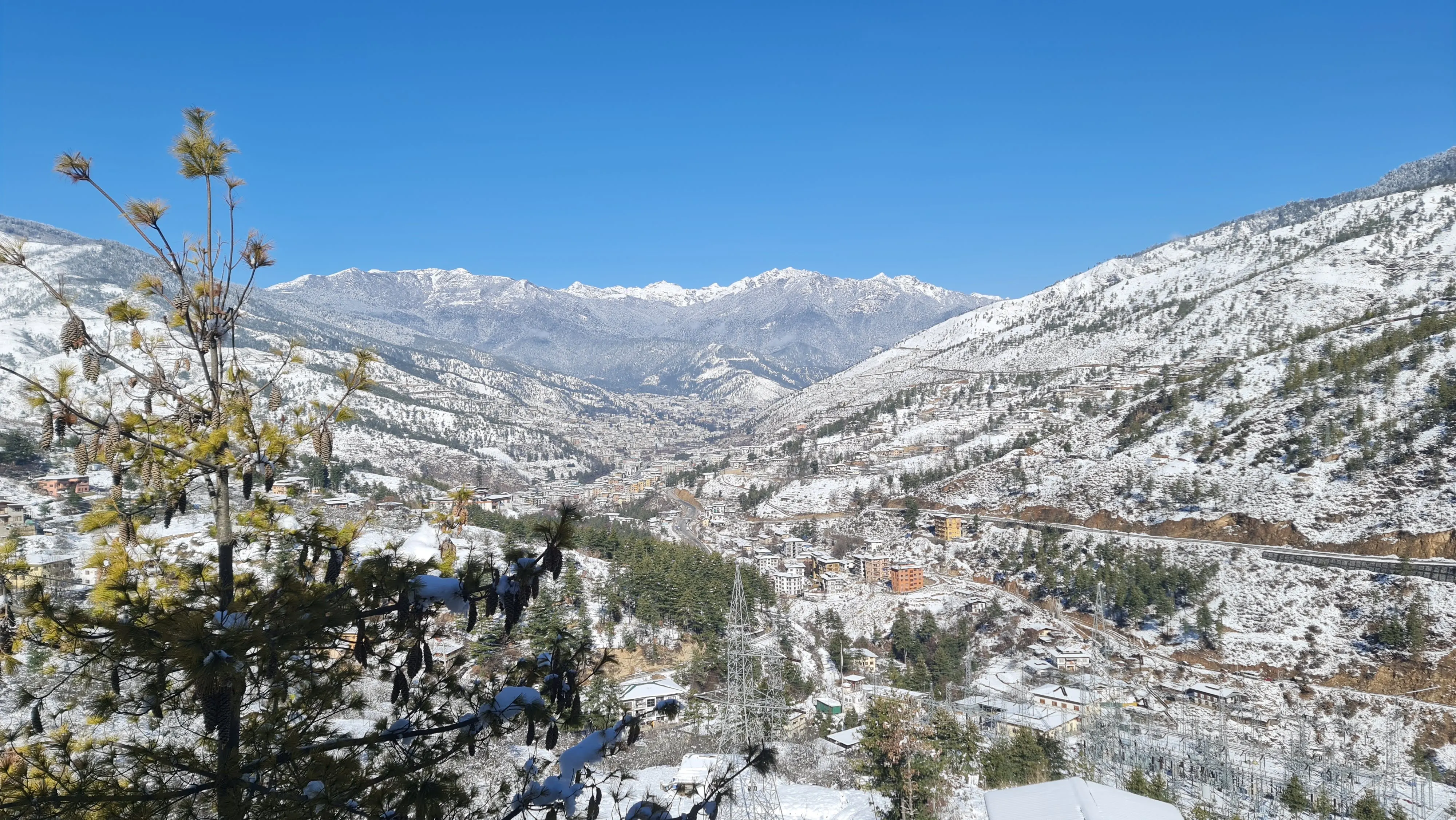A snow-covered Bhutanese valley and town beneath white Himalayan peaks